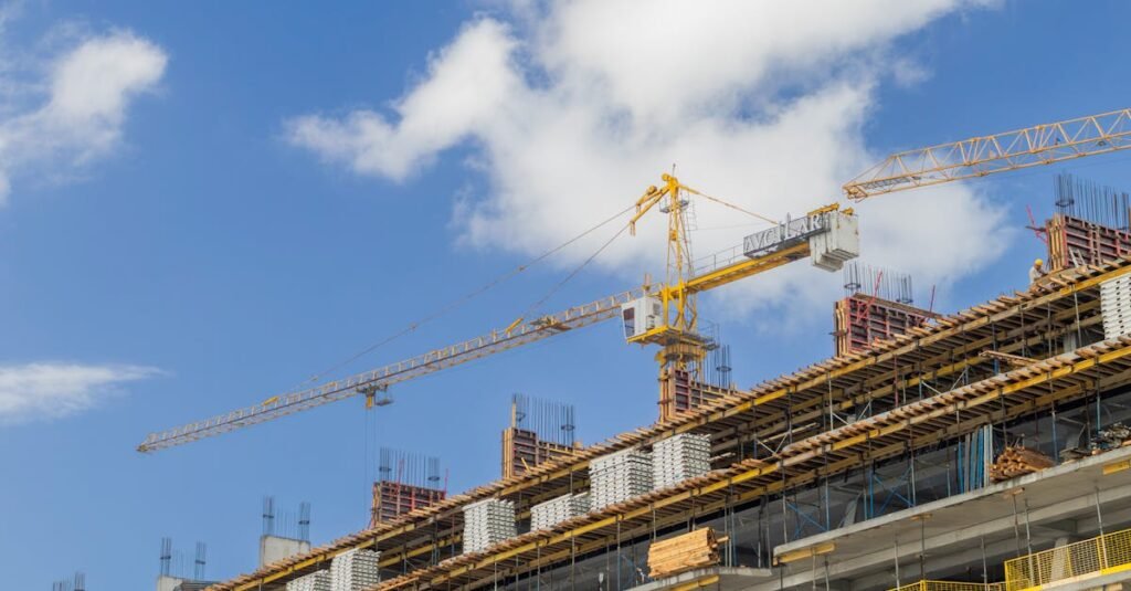 pexels-photo-36065437-36065437 A modern construction site with cranes against a clear blue sky, showcasing urban development.